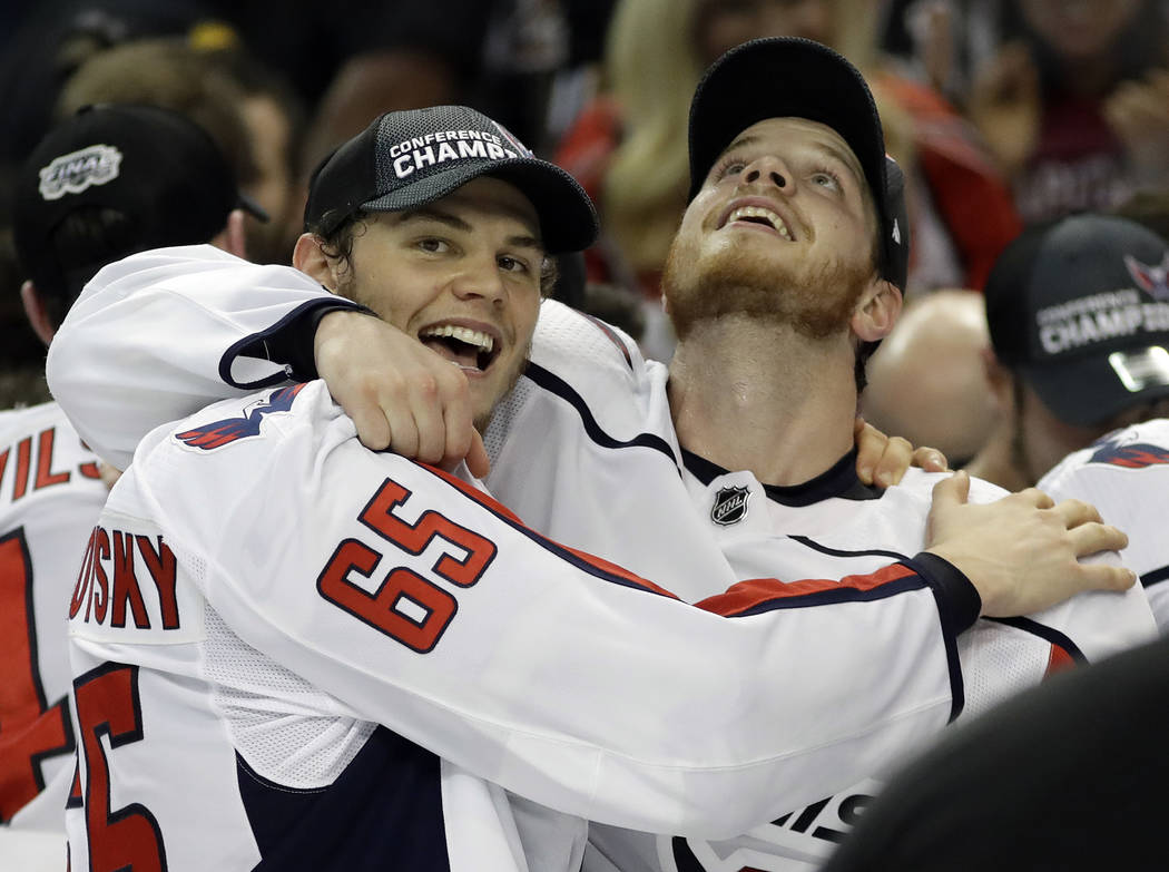 Washington Capitals left wing Andre Burakovsky (65) and defenseman John Carlson celebrate after the Capitals defeated the Tampa Bay Lightning 4-0 during Game 7 of the NHL Eastern Conference finals ...
