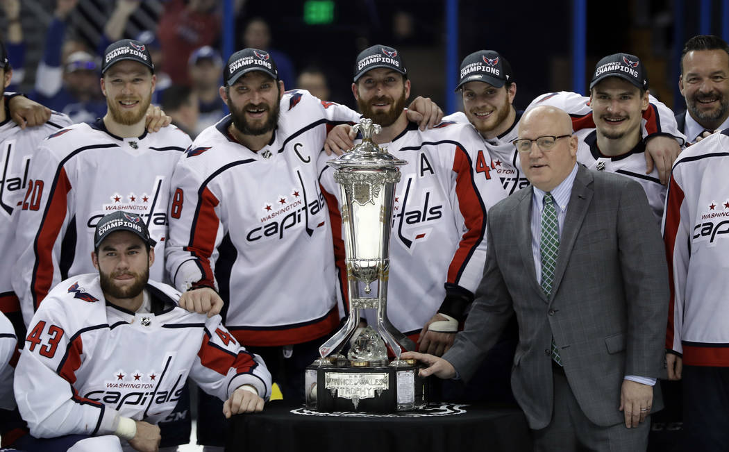 NHL Deputy Commissioner Bill Daly, right, poses with members of the Washington Capitals and the Prince of Wales trophy after the Capitals defeated the Tampa Bay Lightning 4-0 during Game 7 of the ...