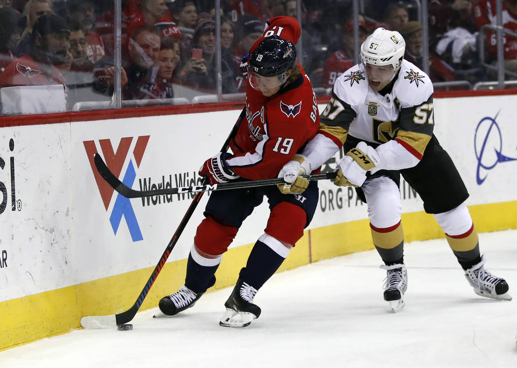 Washington Capitals left wing Jakub Vrana (13), from the Czech Republic, skates with the puck as Vegas Golden Knights left wing David Perron (57) reaches for it in the first period of an NHL hocke ...