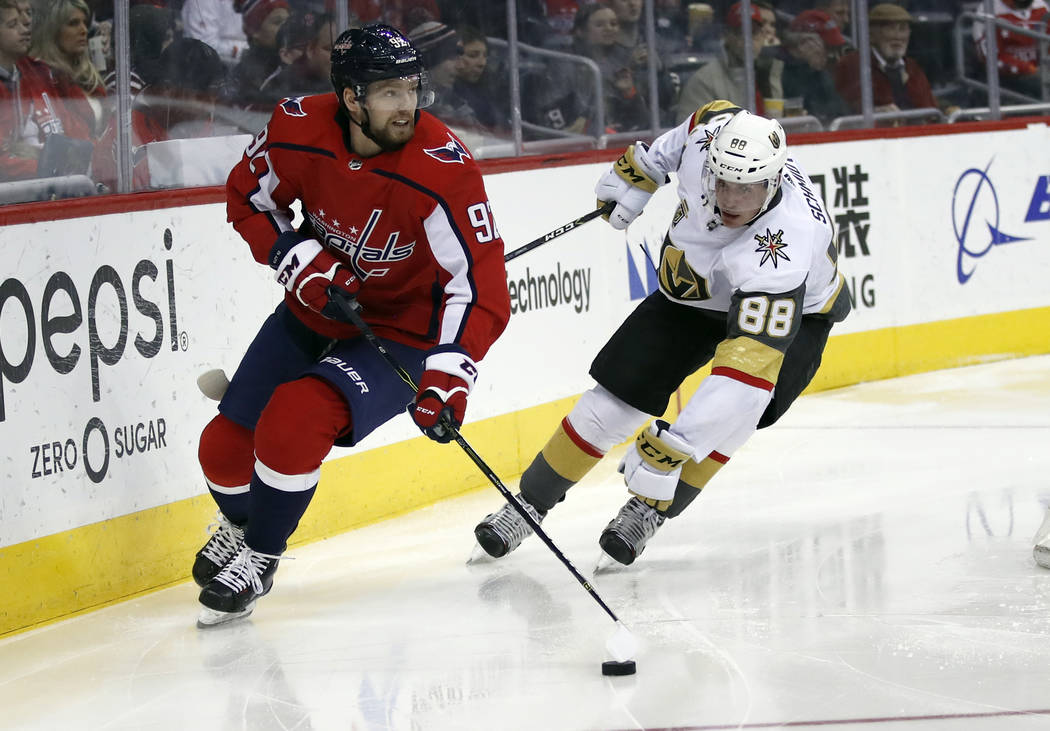 Washington Capitals center Evgeny Kuznetsov (92), from Russia, looks to pass as Vegas Golden Knights defenseman Nate Schmidt (88) defends in the second period of an NHL hockey game, Sunday, Feb. 4 ...