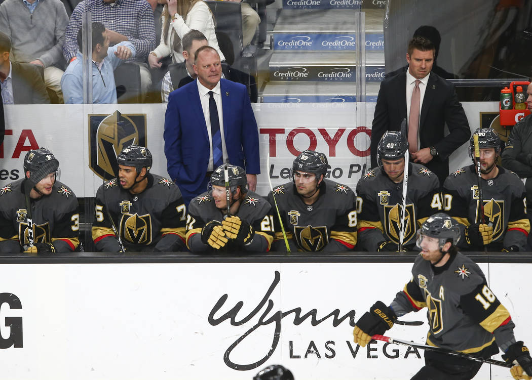 Golden Knights head coach Gerard Gallant, in blue, watches the action as his team plays the Vancouver Canucks during the second period of an NHL hockey game at T-Mobile Arena in Las Vegas on Tuesd ...