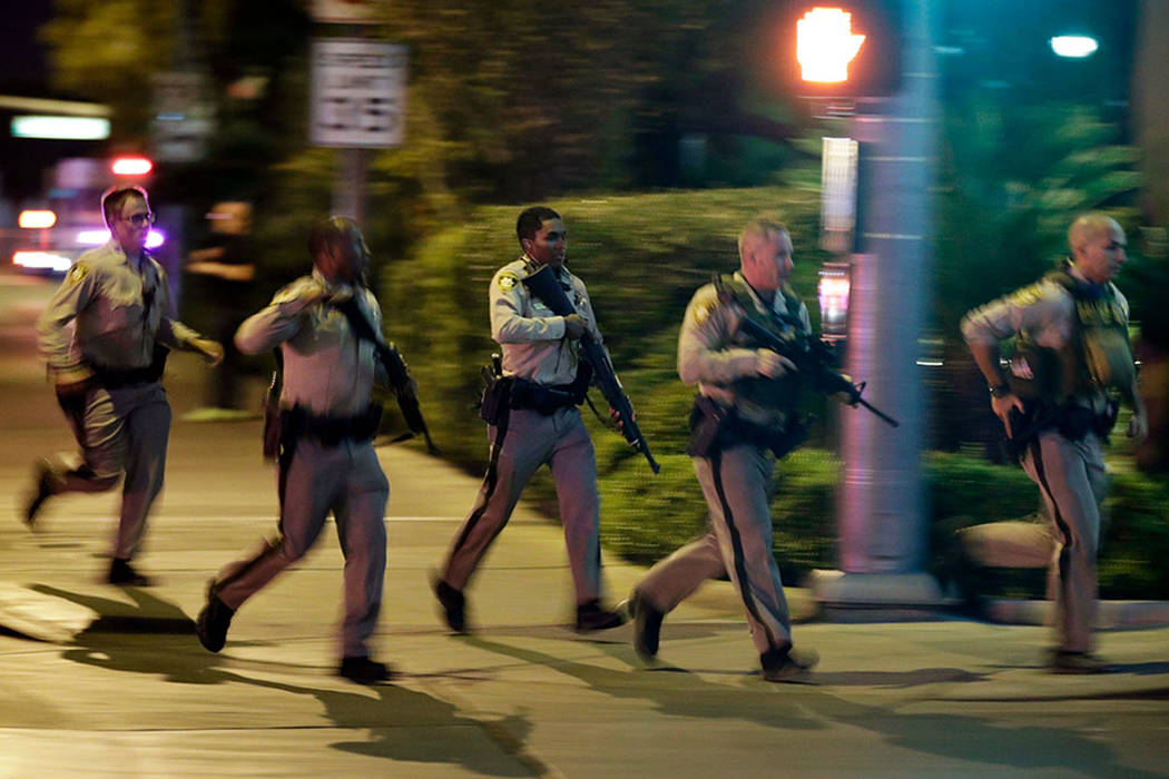 Police run toward the scene of a mass shooting near Mandalay Bay in Las Vegas on Oct. 1, 2017. (AP Photo/John Locher)