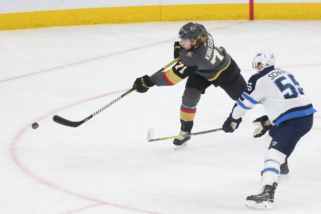 Vegas Golden Knights center William Karlsson (71) takes a shot under pressure from Winnipeg Jets center Mark Scheifele (55) during the first period in Game 4 of the Western Conference Final at T-M ...