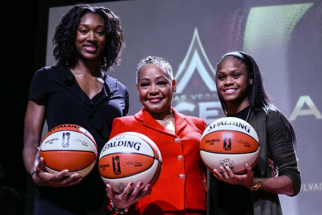 Las Vegas Aces' Kayla Janine Alexander, left, WNBA President Lisa Borders, center, Las Vegas Aces' Moriah Jefferson, right, gather during the reveal of the Las Vegas Aces WNBA basketball team at t ...