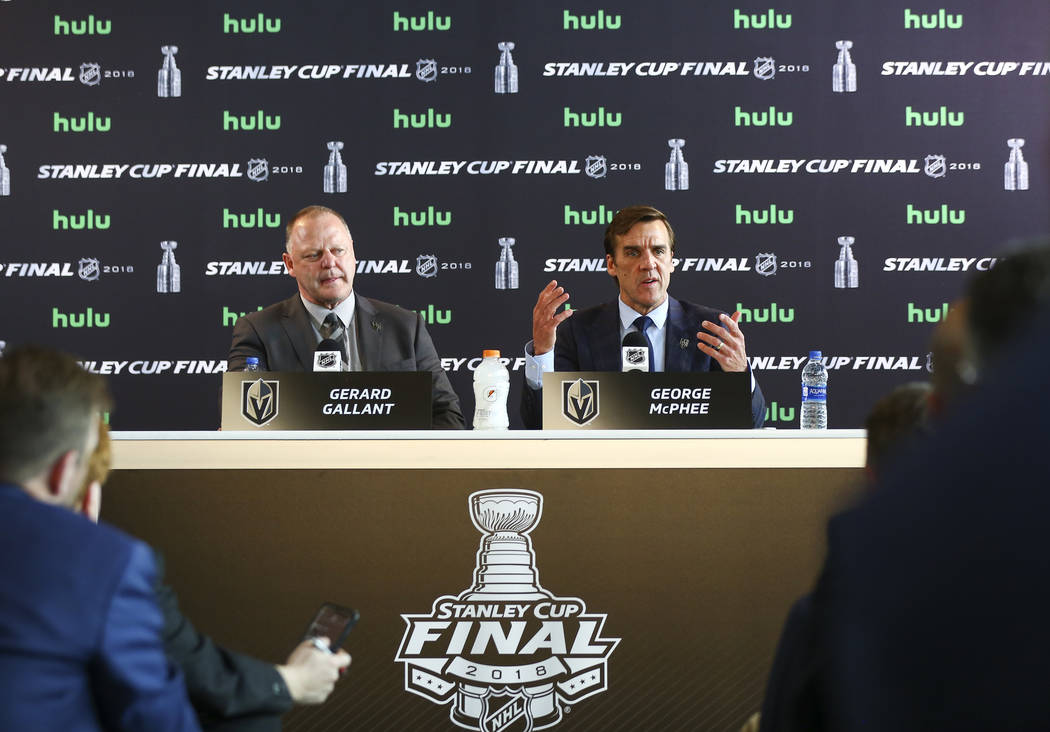 Golden Knights head coach Gerard Gallant, left, looks on as George McPhee, general manager of the team, speaks during NHL hockey media day for the Stanley Cup Final at the T-Mobile Arena in Las Ve ...