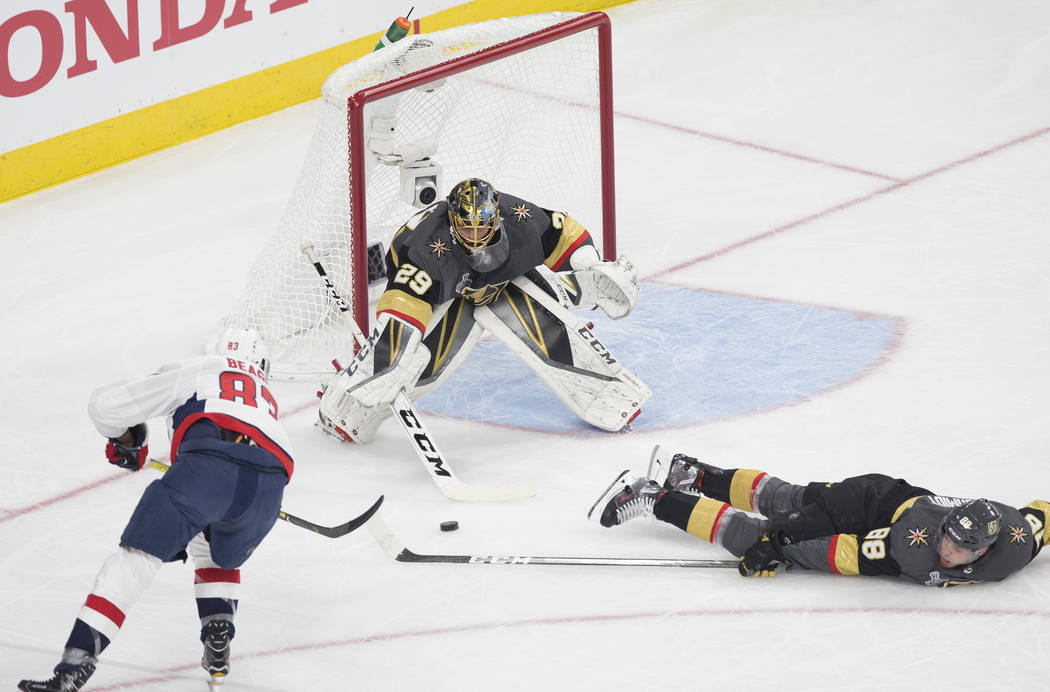 Golden Knights goaltender Marc-Andre Fleury (29) makes a save with the help of defenseman Nate Schmidt (88) against Capitals right wing Jay Beagle (83) in the first period during Vegas' Game 1 mat ...