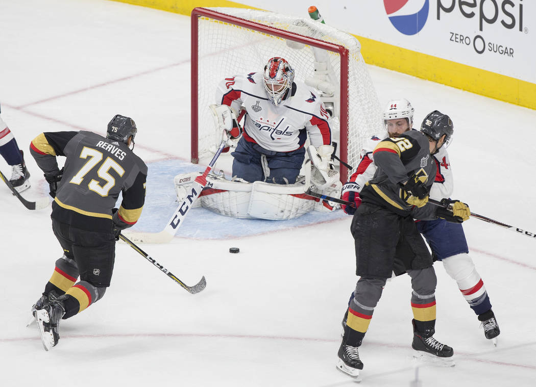 Capitals goaltender Braden Holtby (70) makes a first-period save against Golden Knights right wing Ryan Reaves (75) during Game 1 of the NHL Stanley Cup Finals on Monday, May 28, 2018, at T-Mobile ...
