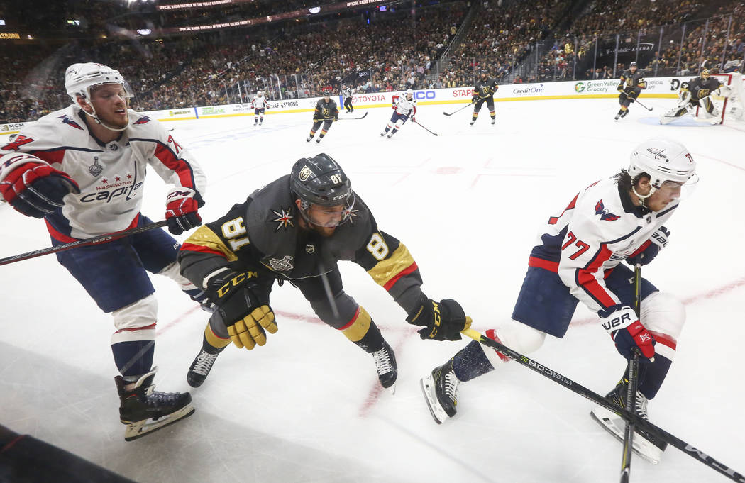 Golden Knights center Jonathan Marchessault (81) battles for the puck between Washington Capitals defenseman John Carlson (74) and right wing T.J. Oshie (77) during the second period of Game 1 of ...