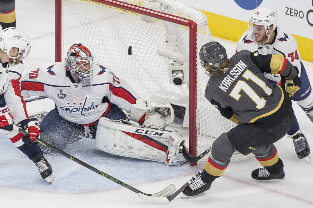 Golden Knights center William Karlsson (71) scores a first-period goal against Capitals goaltender Braden Holtby (70) during Game 1 of the NHL Stanley Cup Finals on Monday, May 28, 2018, at T-Mobi ...