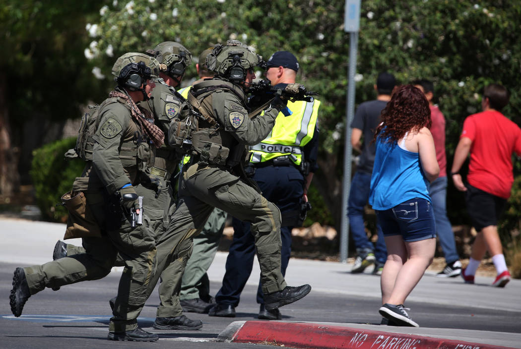 A Las Vegas SWAT team members aim their weapons as they approach Shadow Ridge High School where a mass shooting drill, coordinated by the Metropolitan Police Department and the various agencies in ...