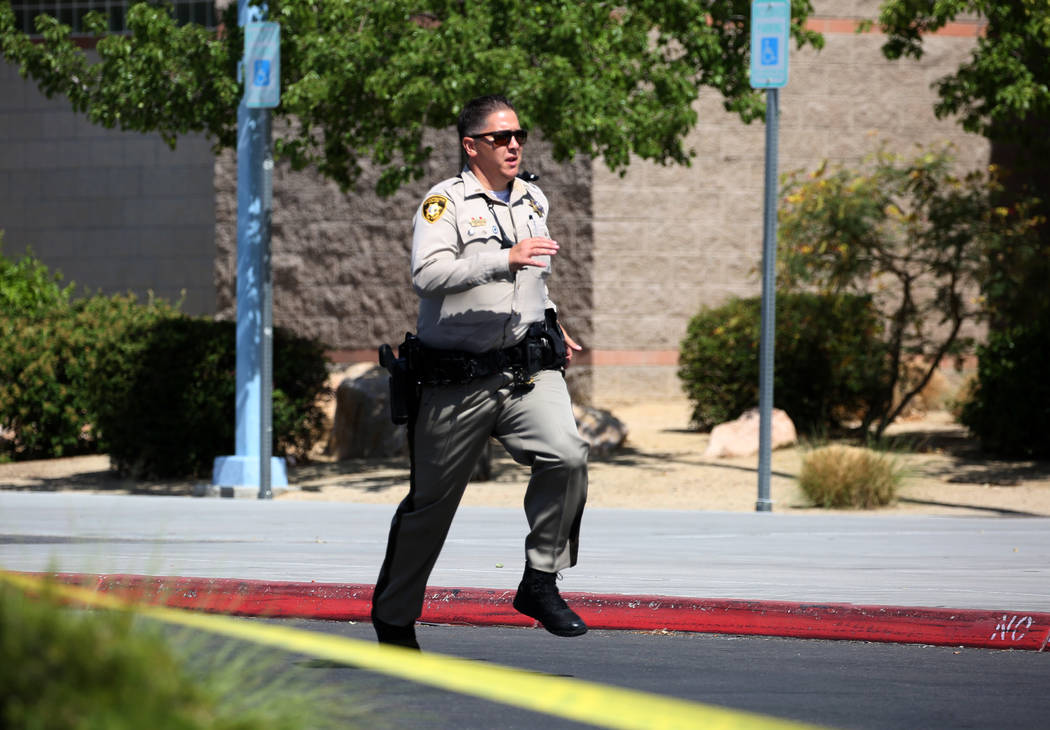 A Las Vegas police officer runs back to his vehicle during a mass shooting drill, coordinated by the Metropolitan Police Department and the various agencies in the area, at Shadow Ridge High Schoo ...