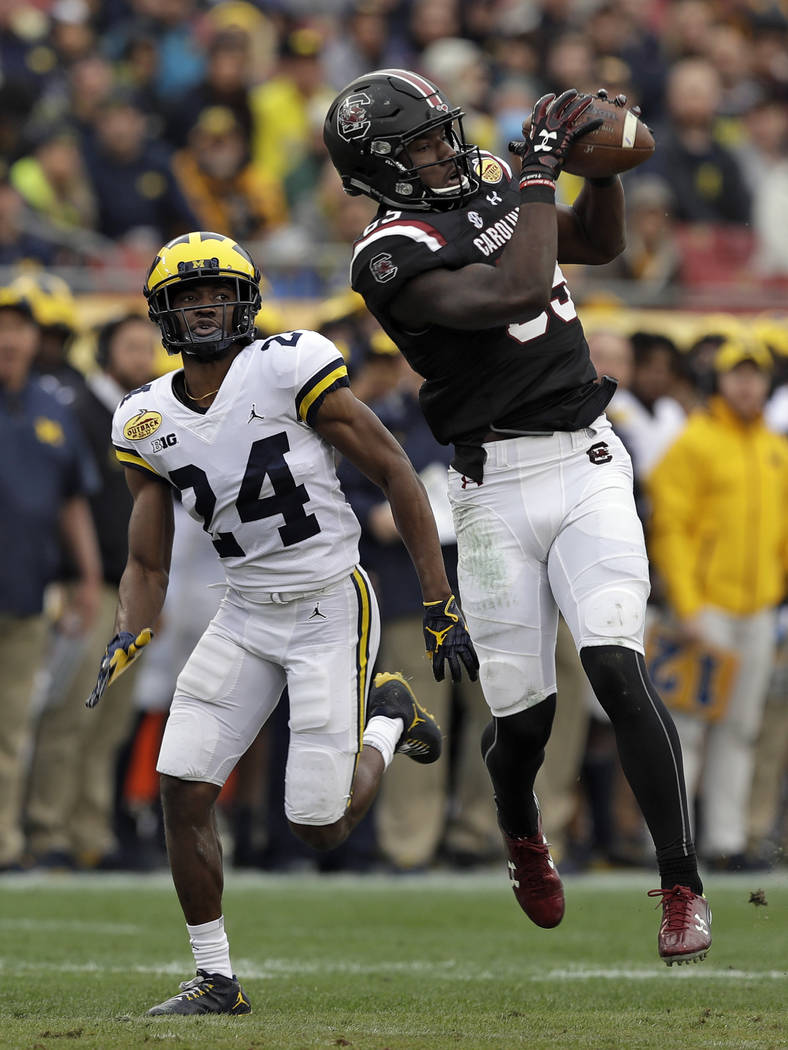 South Carolina wide receiver Bryan Edwards (89) pulls in a pass in front of Michigan defensive back Lavert Hill (24) during the first half of the Outback Bowl NCAA college football game Monday, Ja ...