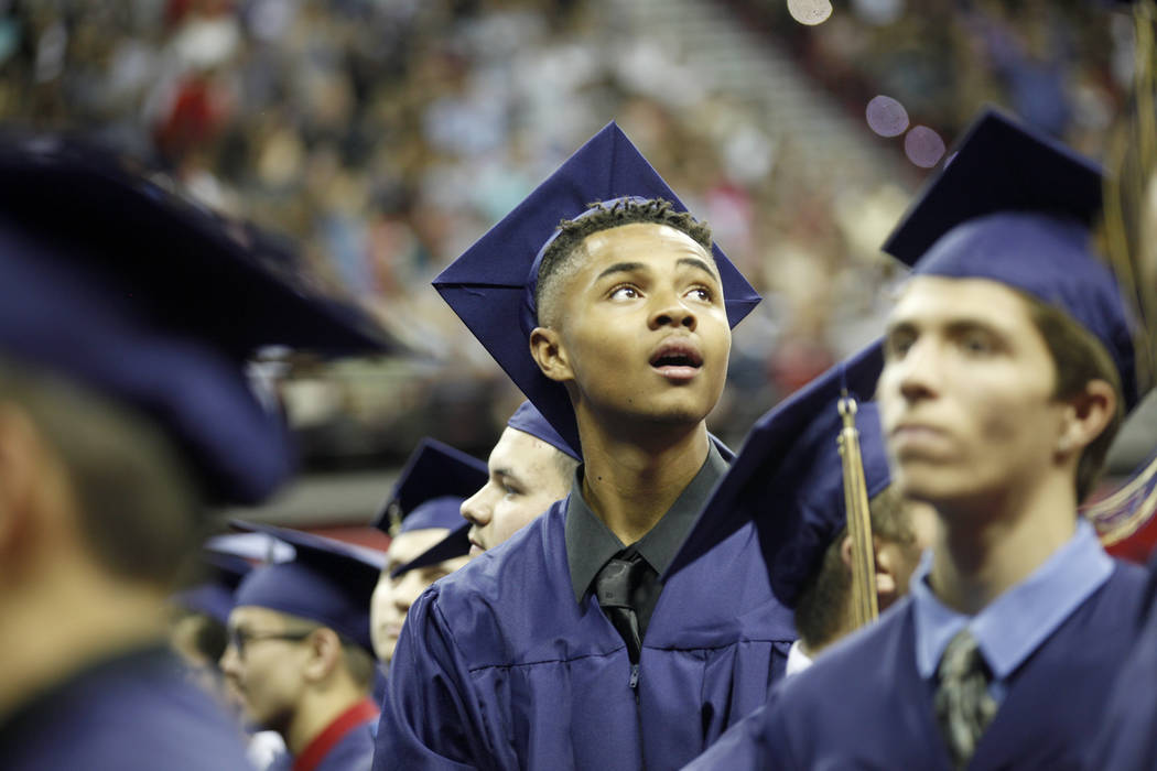 D'Andre Burnett looks for his family in the crowd on graduation day at the Thomas & Mack Center in Las Vegas, Thursday, May 24, 2018. Burnett finished his credits the day before in order to ma ...