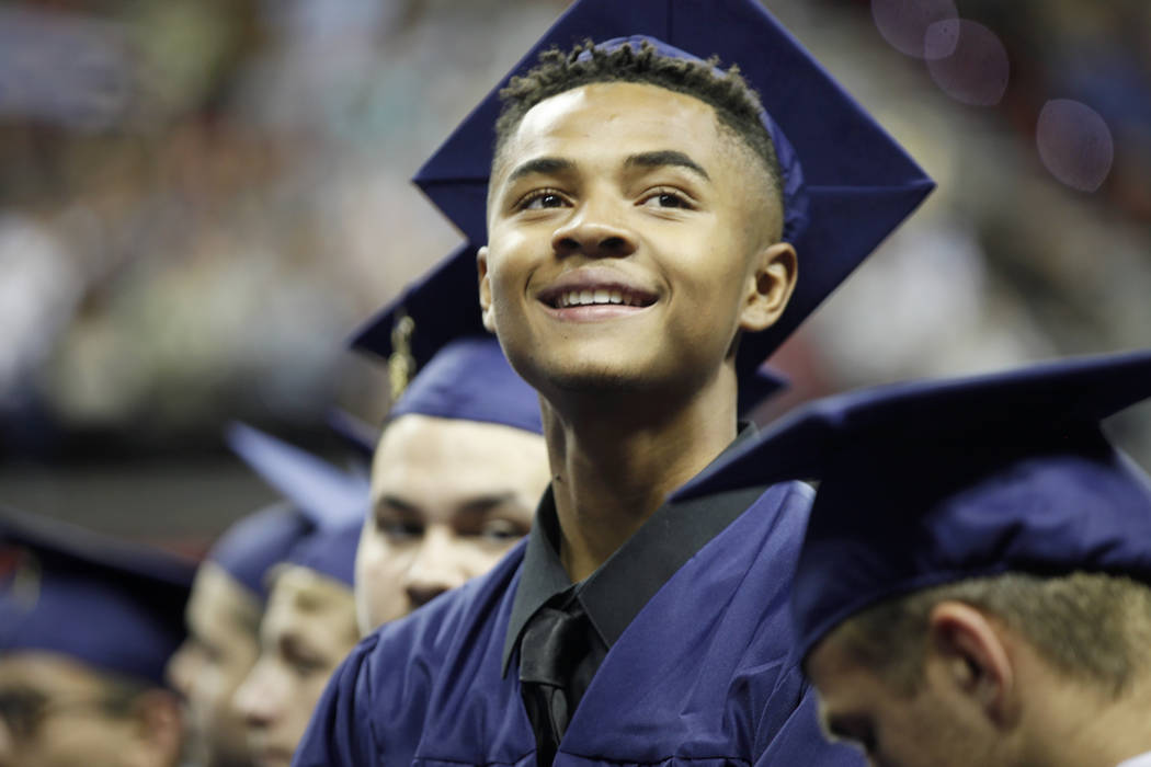 D'Andre Burnett looks for his family in the crowd on graduation day at the Thomas & Mack Center in Las Vegas, Thursday, May 24, 2018. Burnett finished his credits the day before in order to ma ...