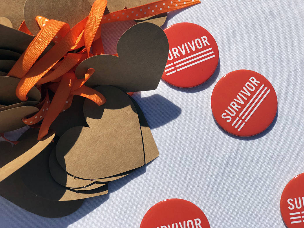 Gun violence prevention group Moms Demand Action hands out survivor pins at the Wear Orange gun violence campaign event at the Las Vegas Community Healing Garden on Saturday, June 2, 2018. (Rio La ...