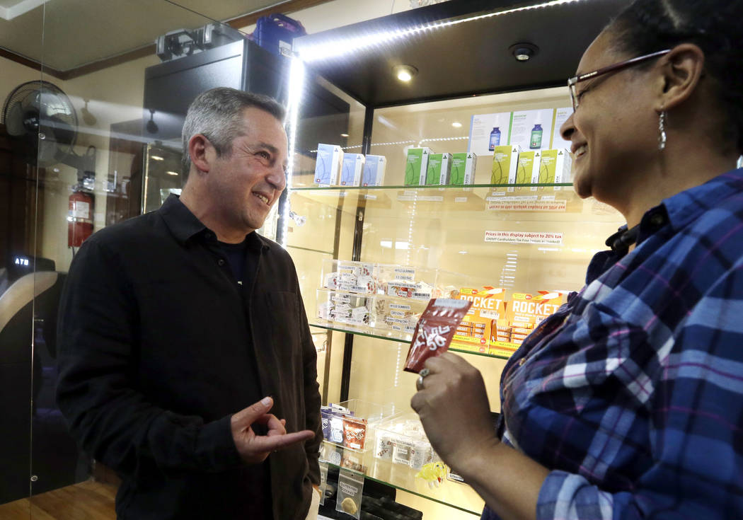 Adam Smith, left, founder and executive director, Oregon Craft Cannabis Alliance, is shown a variety of edible marijuana products by Tree PDX marijuana shop owner Brooke Smith at her shop in Portl ...