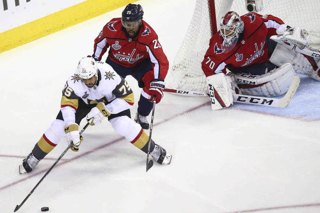 Golden Knights right wing Ryan Reaves (75) controls the puck in front of Washington Capitals right wing Devante Smith-Pelly (25) and goaltender Braden Holtby (70) during the second period of Game ...