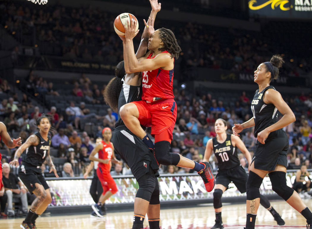 Washington Mystics forward Monique Currie (25) gets fouled by Las Vegas Aces center Kelsey Bone (3) in the first half of a WNBA basketball game at the Mandalay Bay Events Center in Las Vegas on Fr ...