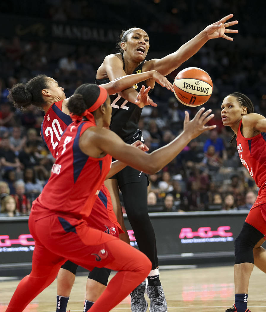 Las Vegas Aces center A'ja Wilson (22) loses the ball and gets fouled by Washington Mystics forward Monique Currie, right, as Mystics guards Kristi Toliver (20) and Ariel Atkins (7) defend in the ...