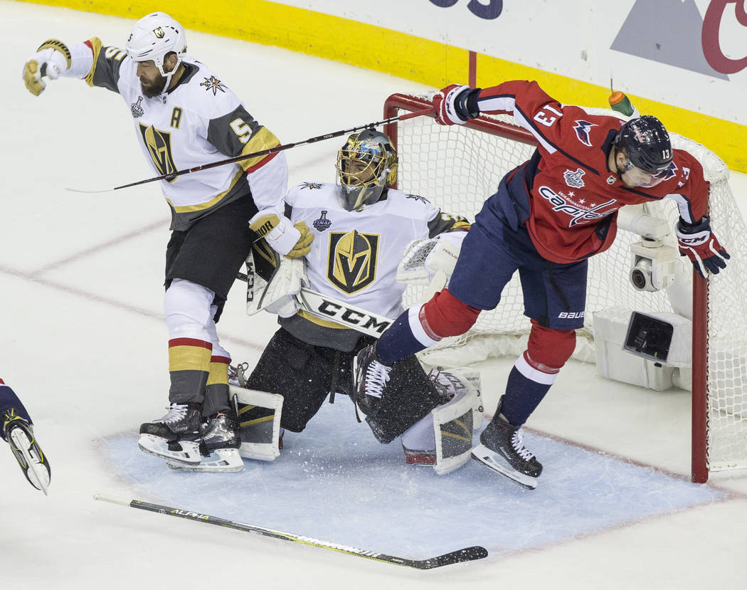 Golden Knights goaltender Marc-Andre Fleury (29) collides with defenseman Deryk Engelland (5) and Capitals left wing Jakub Vrana (13) in the first period during Game 3 of the NHL Stanley Cup Final ...