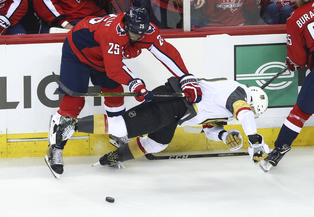 Golden Knights center Cody Eakin (21) gets checked by Washington Capitals right wing Devante Smith-Pelly (25) during the first period of Game 3 of the NHL hockey Stanley Cup Final at Capital One A ...