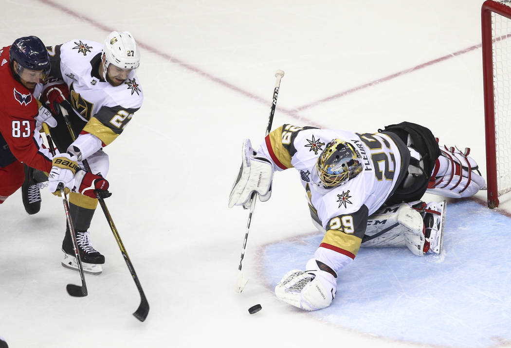 Golden Knights goaltender Marc-Andre Fleury (29) dives for an attempted save in front of Washington Capitals center Jay Beagle (83) and Golden Knights defenseman Shea Theodore (27) during the seco ...