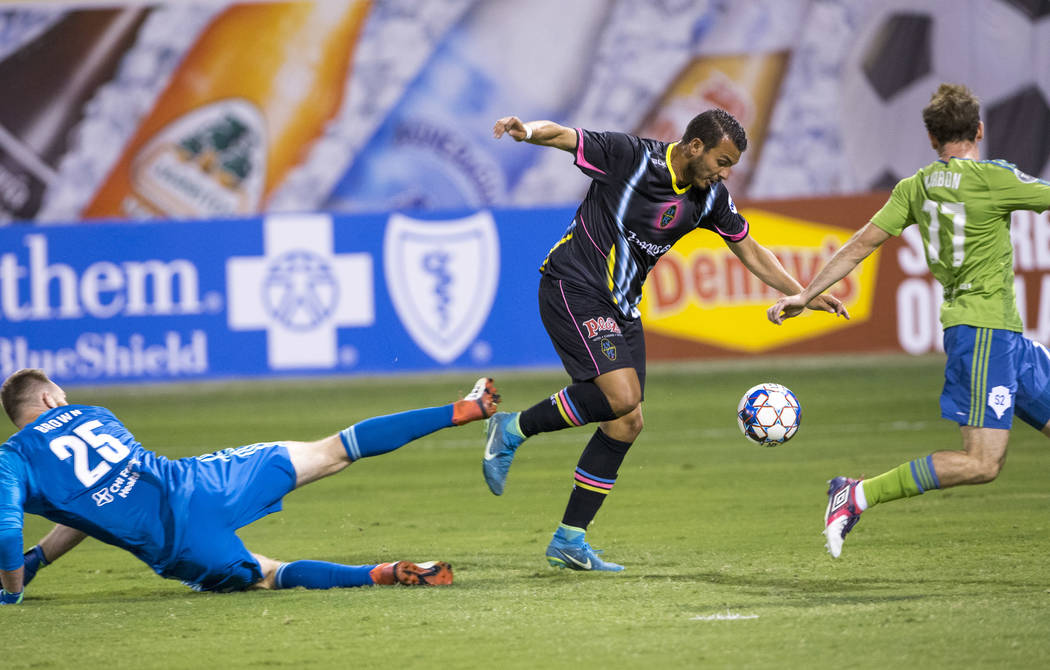 Las Vegas Lights FC forward Sammy Ochoa, center, breaks past Seattle Sounders FC 2 goalie Calle Brown (25) and Sounders midfielder Francisco Narbon (77) for a goal during the first half of a Unite ...