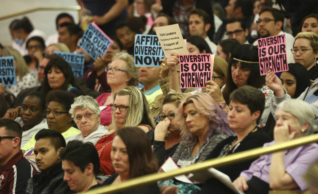 Attendees hold up signs in support of a gender-diverse policy for the school district during a Clark County School District Board of Trustees meeting at the County Government Center in Las Vegas o ...