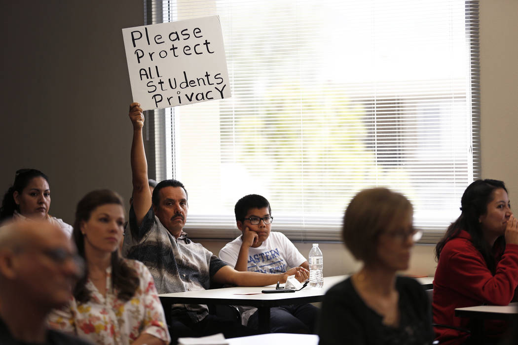 Gerardo Gonzalez, center, and his 13-year-old son, Joel, attend a hearing on proposed gender diverse regulations at the Department of Education's board room in Las Vegas on Friday, March 30, 2018. ...