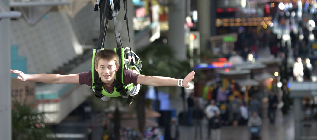 Blake Anderson, son of Clark County firefighter Keith Anderson, rides the zip line during the SlotZilla Charity Challenge of 2015 at the Fremont Street Experience in downtown Las Vegas on Thursday ...