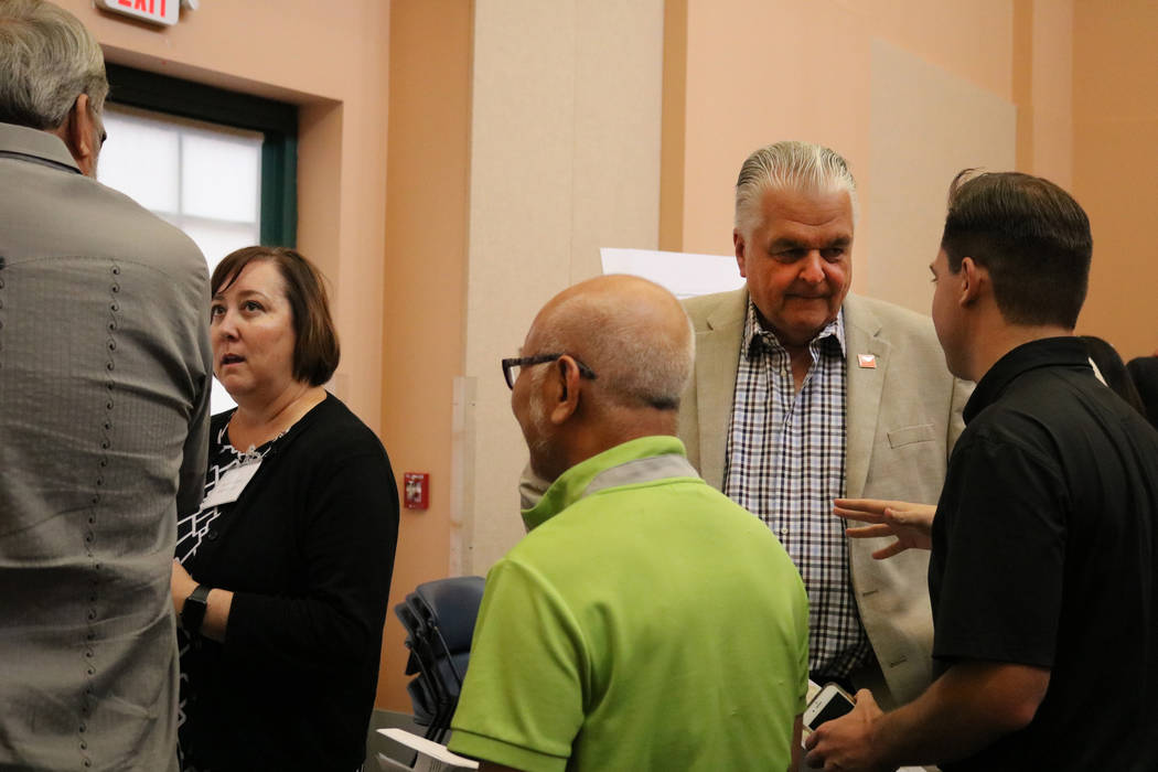 Marci Henson, left, and Clark County Commissioner Steve Sisolak, right, speak to members of the public at an open house at the Clark County Library in Las Vegas, Tuesday, June 5, 2018. A crowd fil ...