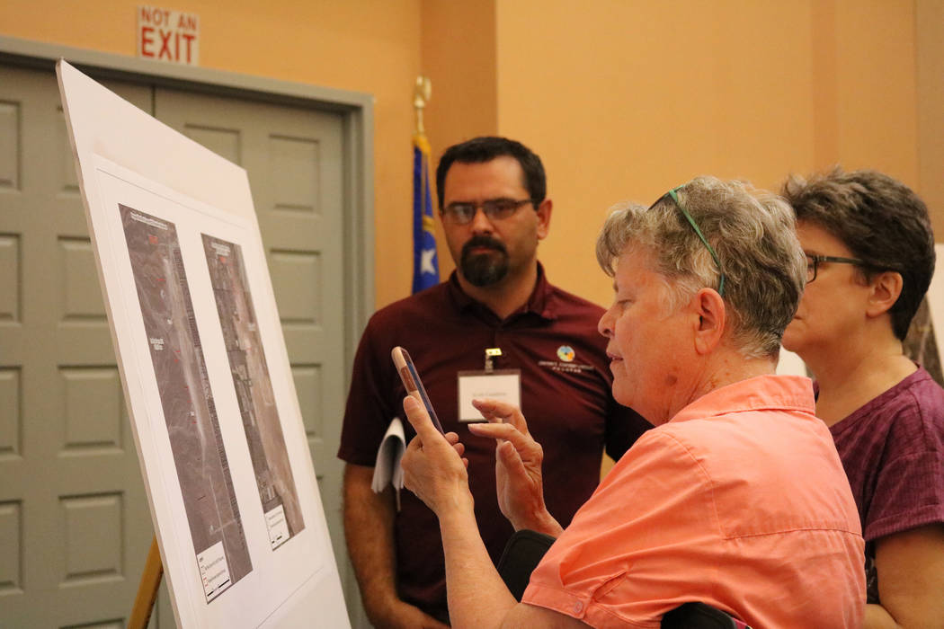 Jane Smith of Las Vegas looks over a poster board while Clark County biologist Scott Cambrin explains a proposed public lands bill at the Clark County Library in Las Vegas, Tuesday, June 5, 2018. ...