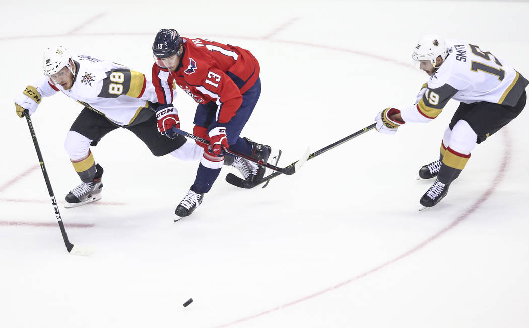 Golden Knights defenseman Nate Schmidt (88) and Golden Knights right wing Reilly Smith (19) chase after the puck against Washington Capitals left wing Jakub Vrana (13) during the third period of G ...