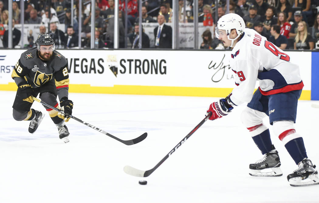 Washington Capitals defenseman Dmitry Orlov (9) moves the puck as Golden Knights left wing William Carrier (28) defends during the first period of Game 5 of the Stanley Cup Final at T-Mobile Arena ...