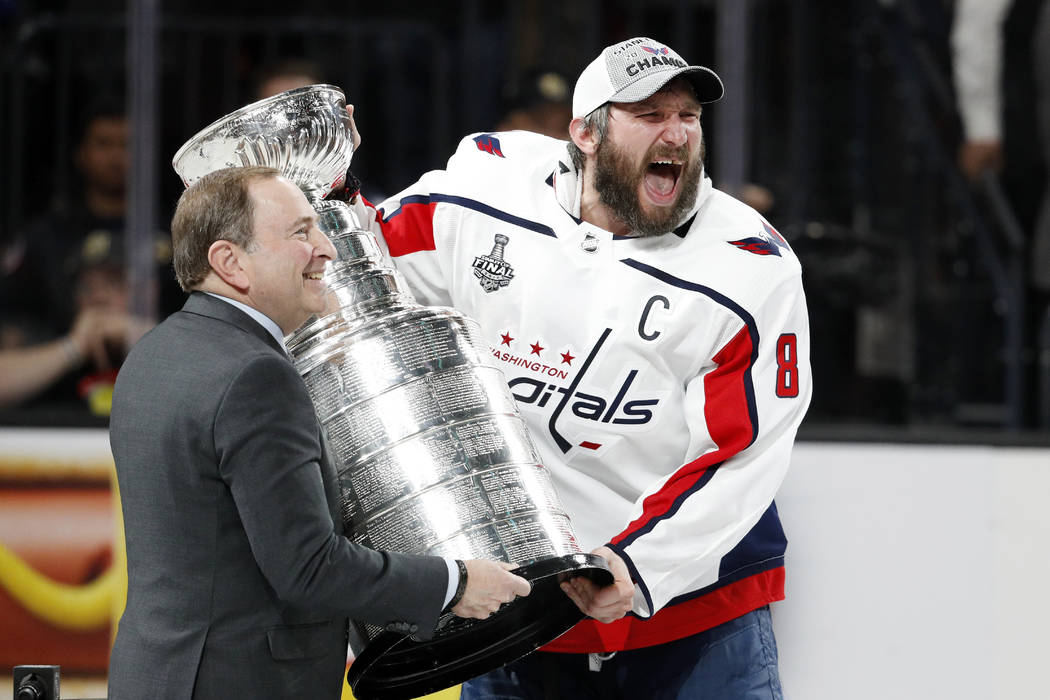 Washington Capitals left wing Alex Ovechkin, right, of Russia, celebrates as he takes the Stanley Cup from NHL commissioner Gary Bettman after the Capitals defeated the Golden Knights 4-3 in Game ...