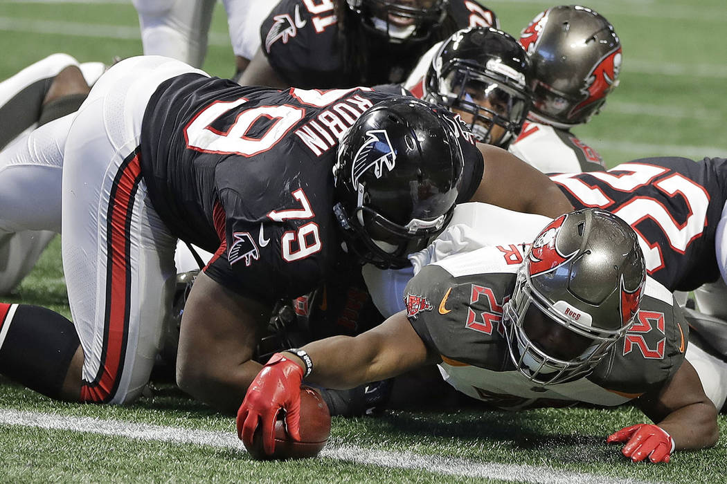 Tampa Bay Buccaneers running back Peyton Barber (25) reaches over the goal line for a touchdown against Atlanta Falcons defensive tackle Ahtyba Rubin (79) during the second half of an NFL football ...