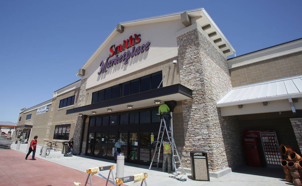 Workers from Redd Roofing of Ogden, Utah put final touches on the storefront of the new 125,000-square-foot Smith’s Marketplace on Skye Canyon Road on Tuesday, June 12, 2018 the day before ...