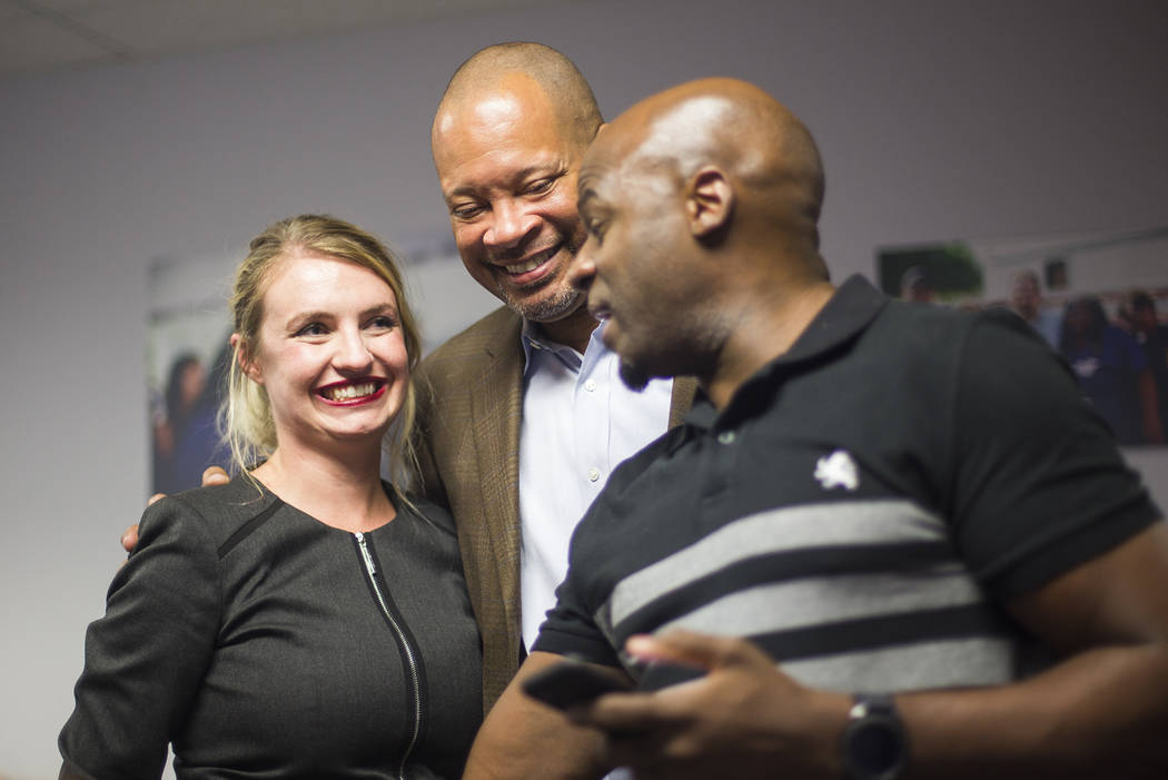 Melanie Scheible, a Democrat running for state Senate District 9, hugs Senate Majority Leader Aaron Ford, D-Las Vegas who is running for Attorney General, next to Sen. Kelvin Atkinson, (D-North La ...