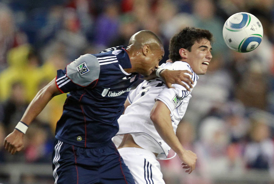 New England Revolutions' Darrius Barnes, left, and Vancouver Whitecaps' Omar Salgado try to get a head on the ball in the first half of an MLS soccer game, Saturday, May 14, 2011, in Foxborough, M ...