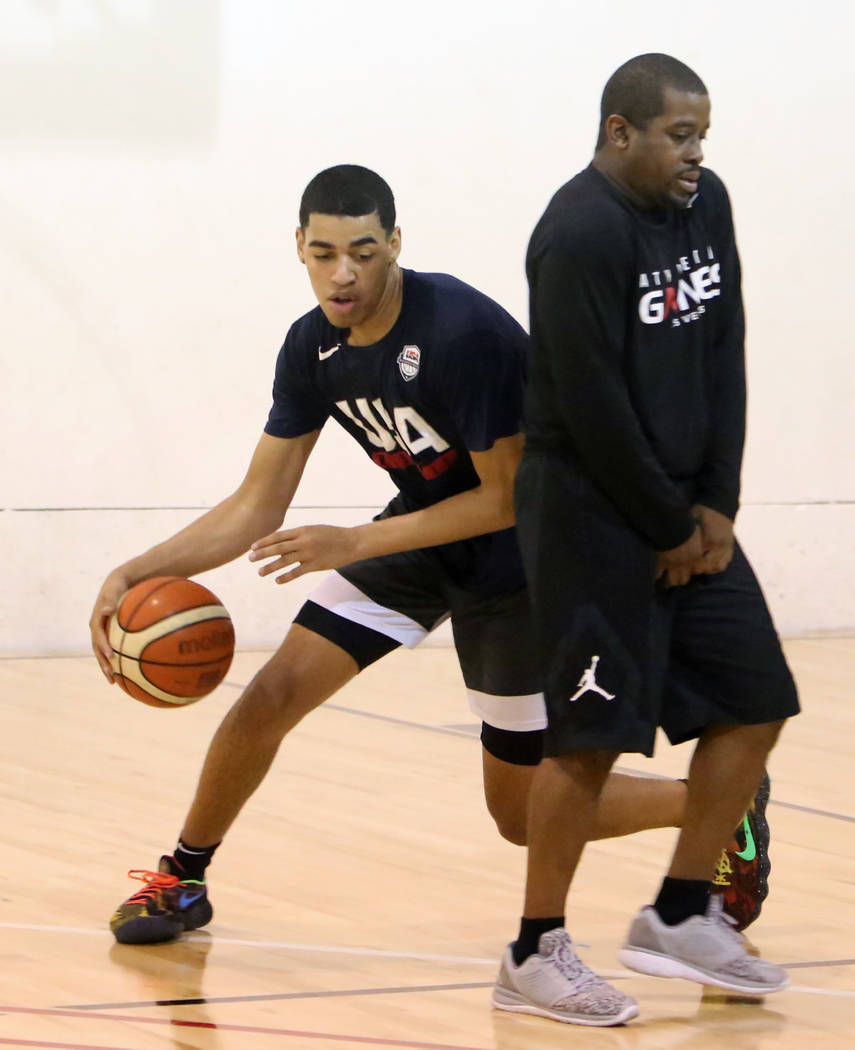 Liberty High School junior Julian Strawther drives past Keith Owens, director of player development at Athletic Gaines, on Tuesday, June 12, 2018 during his workout in preparation for a tryout for ...