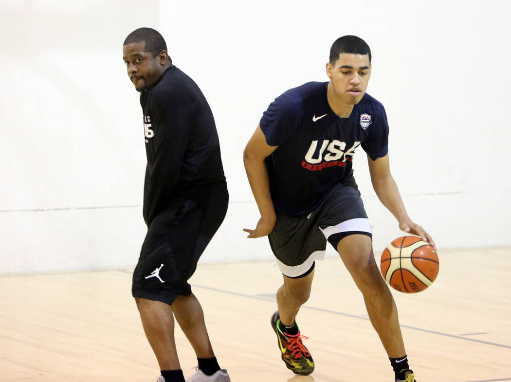 Liberty High School junior Julian Strawther drives past Keith Owens, director of player development at Athletic Gaines, on Tuesday, June 12, 2018 during his workout in preparation for a tryout for ...