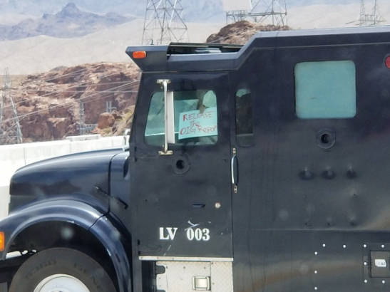 Matthew Wright holds up a sign during the standoff in the southbound lanes on the Mike O’Callaghan-Pat Tillman Bridge near the Hoover Dam on Friday. (Mark Mills via Twitter)