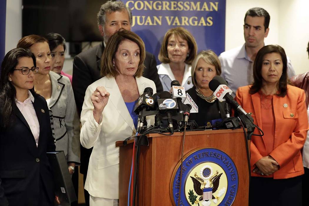 House Minority Leader Nancy Pelosi, D-Calif., at podium, speaks in front of members of the Congressional Hispanic Caucus during a visit to the border Monday, June 18, 2018, in San Diego. The membe ...