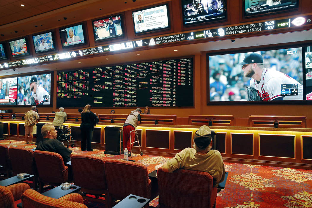 People make bets in the sports book at the South Point hotel and casino in Las Vegas in May 2018. (AP Photo/John Locher)