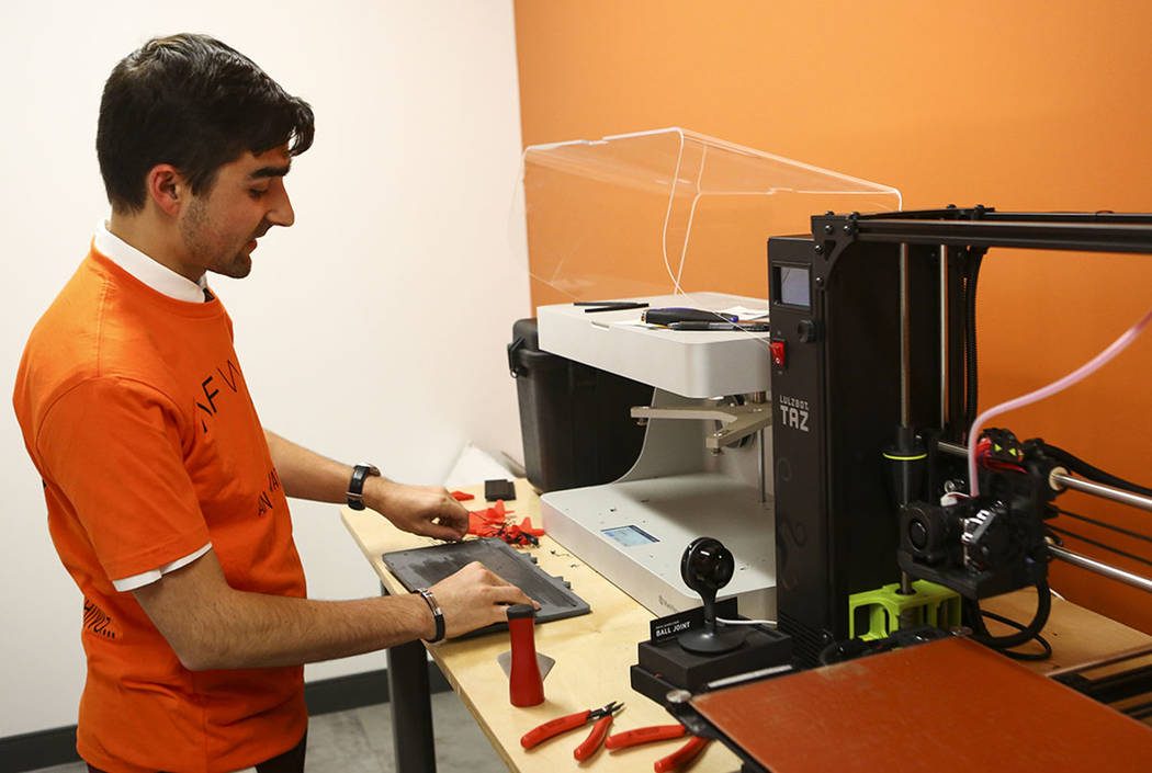 Matthew Viton, prototyping lab coordinator, looks at a 3D printer during a tour of the lab at the grand debut of the completed Innovation Center and lab at AFWERX Vegas in Las Vegas on Tuesday, Ju ...