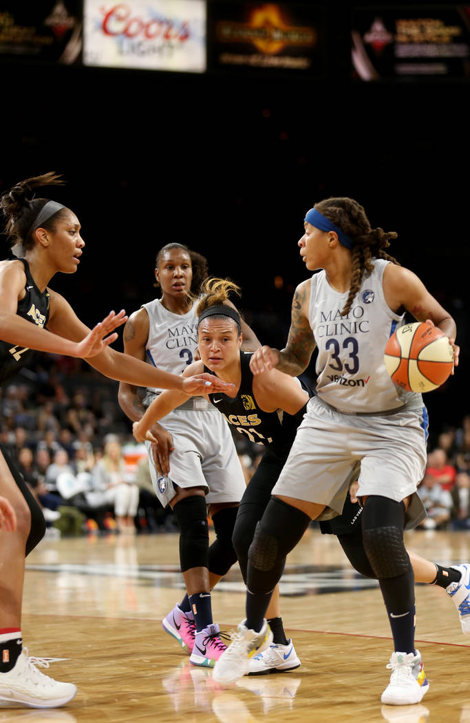 Minnesota Lynx Seimone Augustus (33) attempts to pass the ball past Las Vegas Aces A'ja Wilson (22) and Las Vegas Aces Kayla McBride (21) in the first half of a WNBA basketball game at the Mandala ...