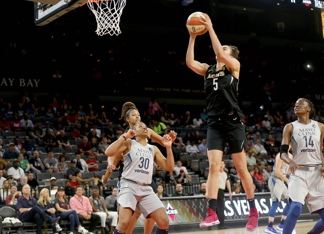 Las Vegas Aces forward Dearica Hamby (5) takes a shot in front of Minnesota Lynx guard Tanisha Wright (30) and center Temi Fagbenle (14) in the first half of a WNBA basketball game at the Mandalay ...