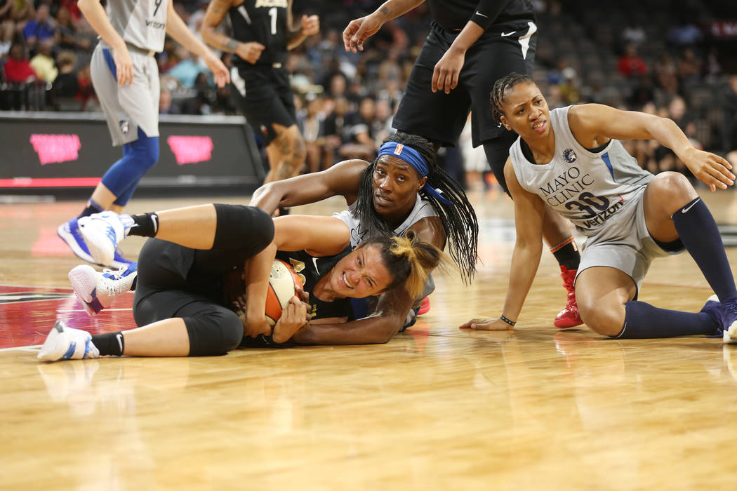 Las Vegas Aces guard Kayla McBride (21) grabs the ball from Minnesota Lynx players center Sylvia Fowles (34) and guard Tanisha Wright (30) at a WNBA basketball at the Mandalay Bay Events Center in ...