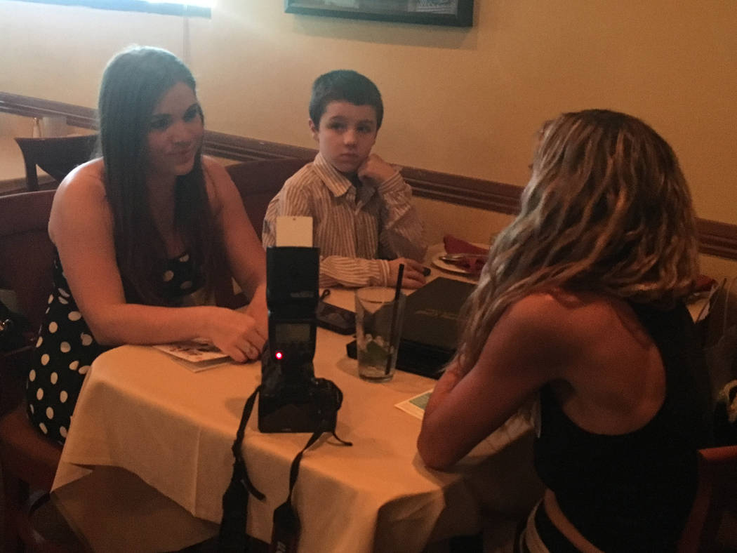 Business owner Melissa Cote and her 8-year-old son Brennan chat with photographer Ati Grinspun, right, at the Henderson MOB chapter launch at Tuscany Grill at 11105 S. Eastern Ave. on June 27. (Ba ...
