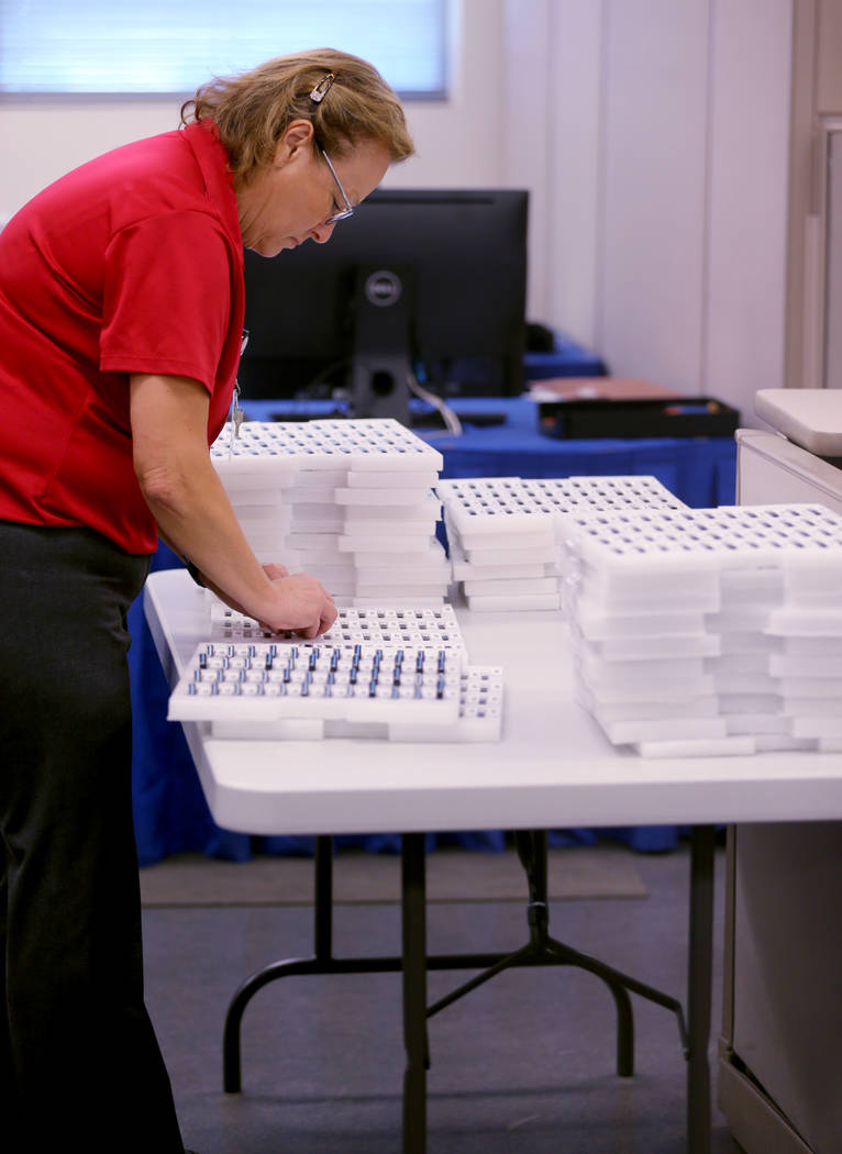A Clark County election worker loads voting machine results cartridges during a recount of the Democratic primary for the County Commission District E seat at election headquarters in Las Vegas Tu ...